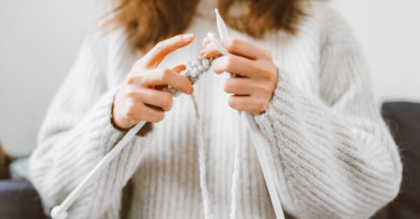 Kvinde i sweater strikker